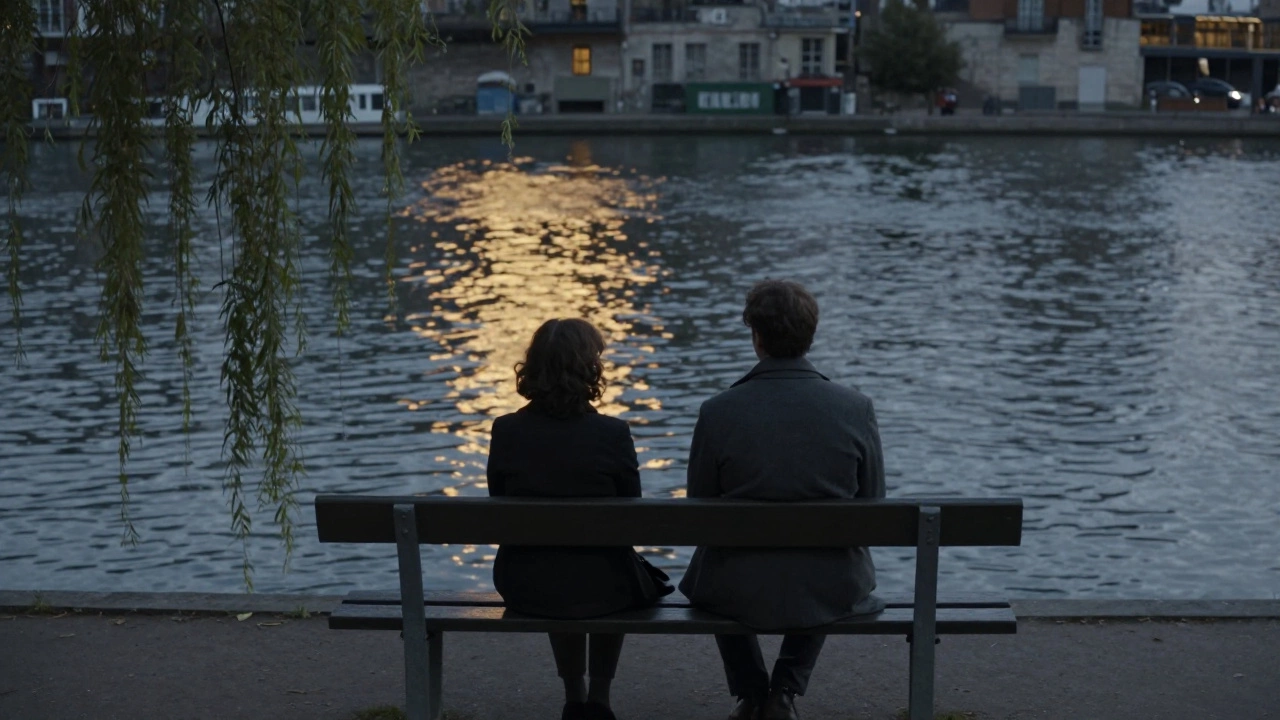 Two people sit peacefully on a canal bench at dusk, the water glowing with golden light.
